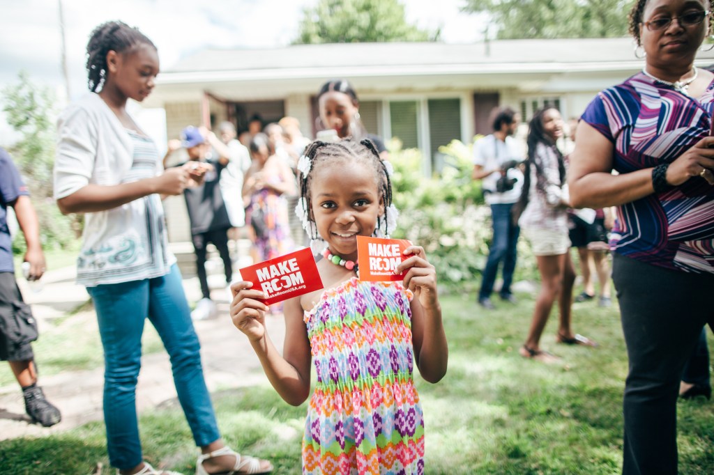 Makayla holds up Make Room signs after the campaign visits Detroit.