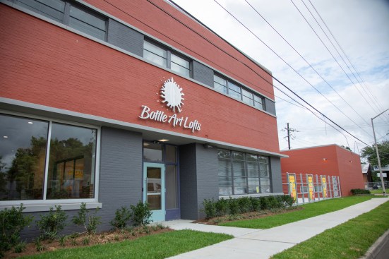 The two phases of Bottle Art Lofts in Lafayette, Louisiana, feature the adaptive-reuse of a a former Coca-Cola bottling facility and new construction on the site of an undesirable motel.