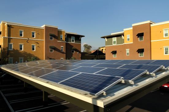 The covered parking includes photovoltaic panels on the rooftops.
