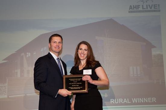 Alta Vista de la Montana in Delta, Colo., which was developed by Community Resources and Housing Development Corp., took the top honor in the rural category. Robin Wolff, director of marketing and resource development at Community Resources and Housing Development Corp., accepts the award from David Leopold, senior vice president of Bank of America Merrill Lynch.