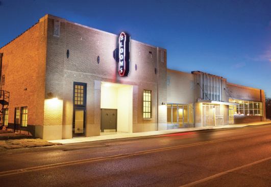 A new vertical sign marks the site of the building’s old theater. The original theater doors remain on the building.