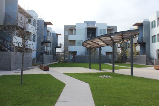 With parking on the perimeter of the site, ample space was left for a large inner courtyard with a tree-lined central green, a built-in barbecue, a children's play area, and a sculptural wood and steel canopy.