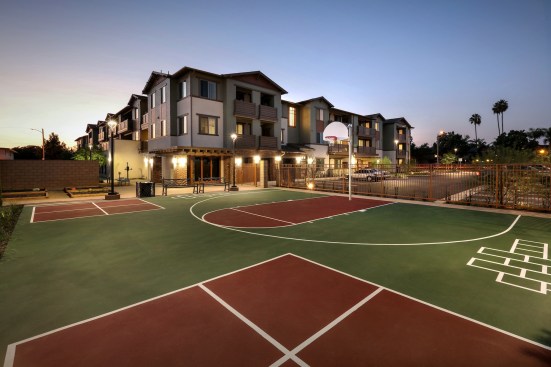 Community amenities include laundry facilities, WiFi access, 115 covered and uncovered parking spaces, an elevator, a tot lot, a half basketball court, a life-sized chess board, fitness stations and equipment, outdoor exercise stations, a barbecue and outdoor dining area, and a community garden. 