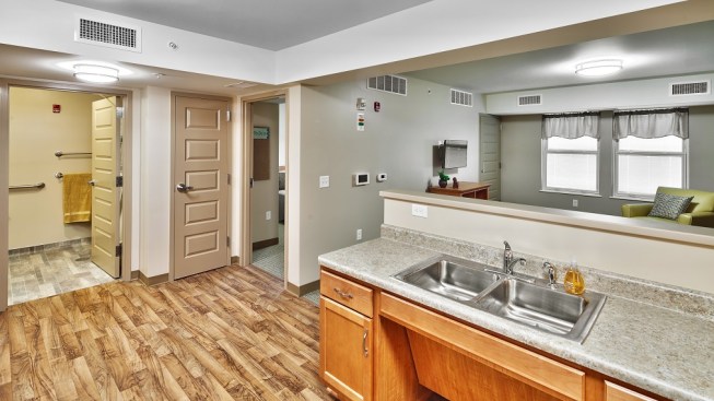 Designed by SWBR Architects, apartment plans are as open as possible, allowing someone in the kitchen to see the bedroom and bathroom doors, the entrance, and the entire living room. Every apartment has a video phone that includes a connection to a vestibule intercom system. The video phone, the apartment doorbell, and the fire and carbon monoxide alarms are all wired to strobe lights and available bed shakers.