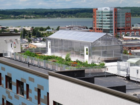 The rooftop features community garden beds and Maine's first rooftop greenhouse where residents can grow produce year-round.